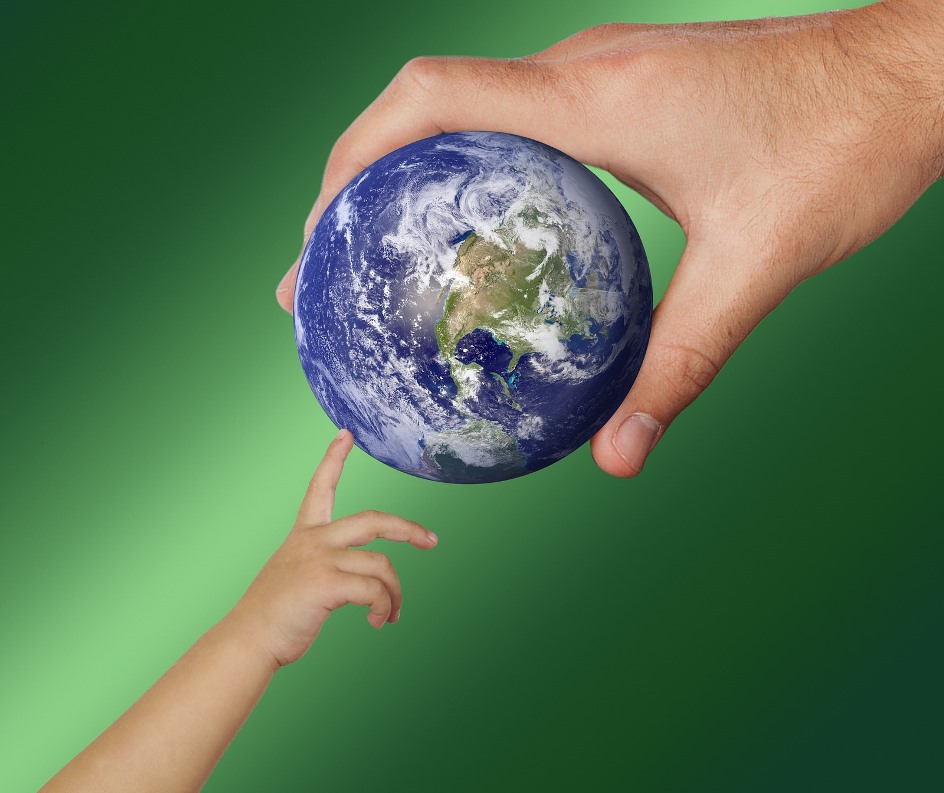 Child's finger reaching to touch an earth ball held in man's fingers