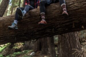 Hikers resting on a log with feet wearing colorful socks